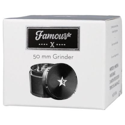 Angled front view of the Famous X 4 pc Grinder -Black - 50mm box showing a black grinder with a white star on its lid beneath the brand logo.