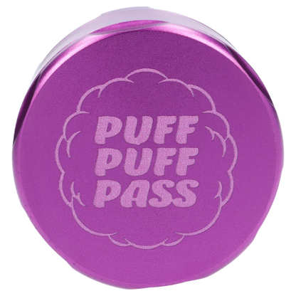 Top-down close-up of the purple Puff Puff Pass Strains Granddaddy Grinder-Purple lid showing raised concentric rings and glittery logo text.