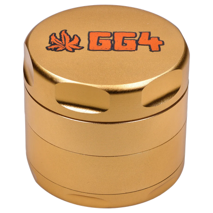 Close-up top-down view of the champagne gold Puff Puff Pass Strains GG4 Grinder-Champagne Gold showing its textured metal finish, recessed grip notches, and orange "GG4" logo with a leaf.