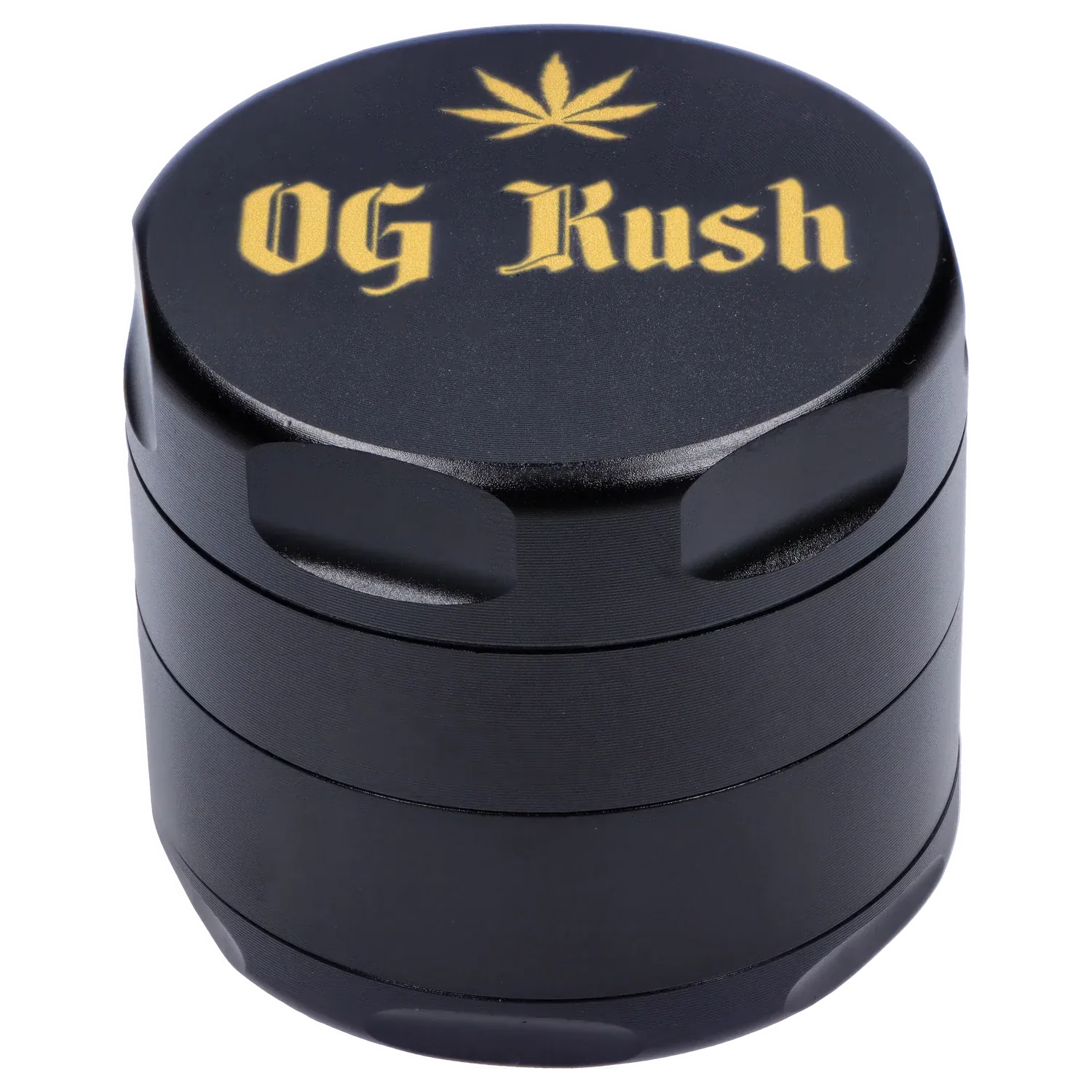 Angled close-up of the black Puff Puff Pass Strains OG Kush Grinder-Black showing its textured lid with gold "OG Kush" lettering and a small leaf motif.