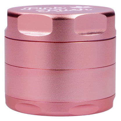 Close-up front view of the metallic light pink Puff Puff Pass Strains Pink Kush Grinder-Light Pink showing textured, stacked cylindrical sections and beveled grip notches.