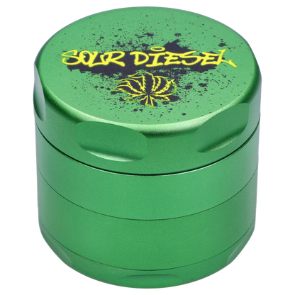 Top-down view of the green Puff Puff Pass Strains Sour Diesel Grinder-Green showing its textured lid with yellow "SOUR DIESEL" graffiti and a stylized leaf.