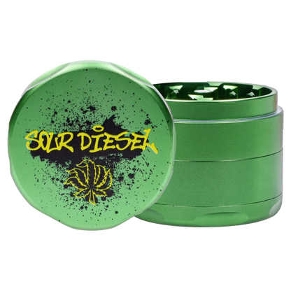Close-up front view of the green Puff Puff Pass Strains Sour Diesel Grinder-Green showing its textured lid with yellow "Sour Diesel" graffiti and a stylized leaf.