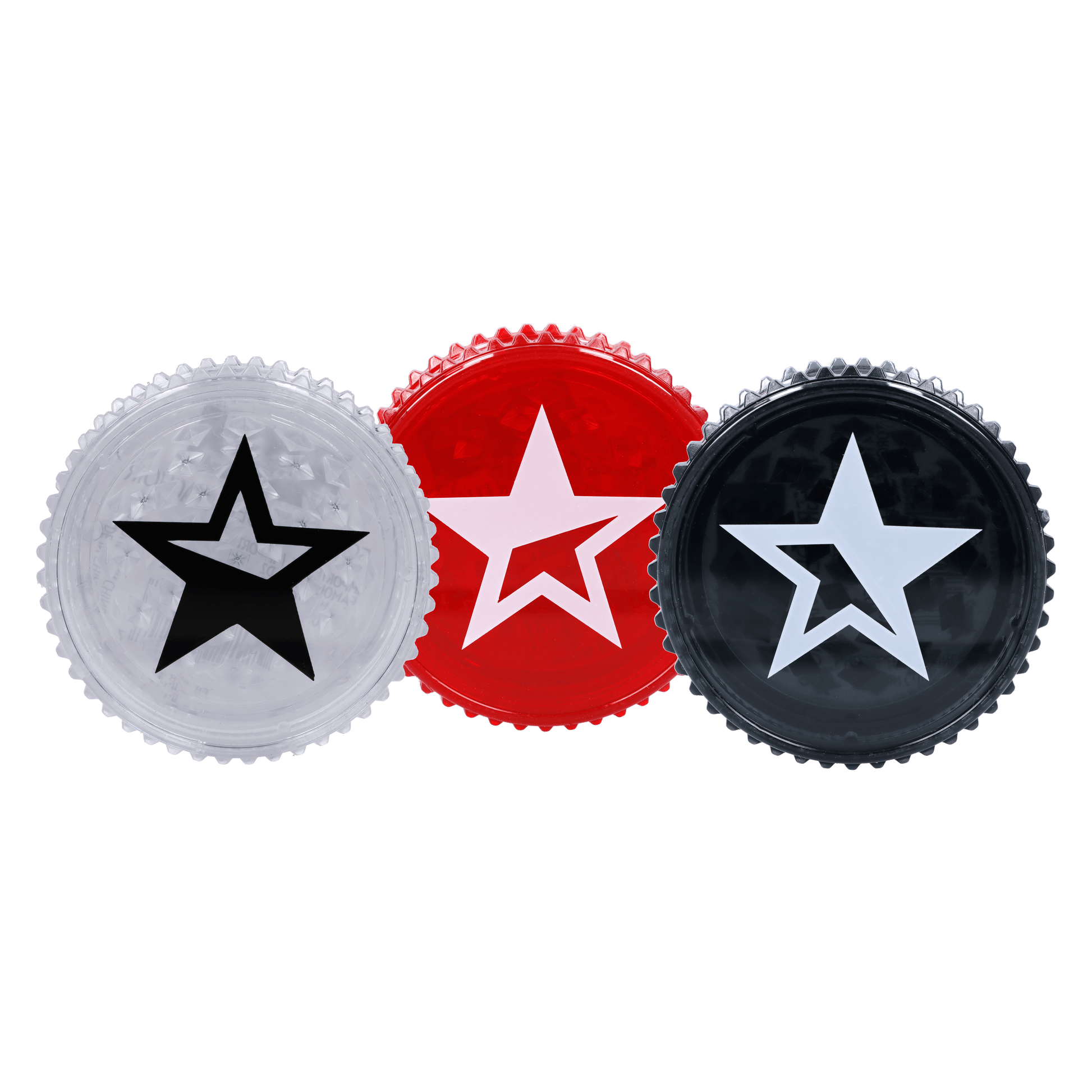 Close-up of three Famous X Acrylic Grinder-59mm tops in a row showing clear, red, and black star-emblazoned lids against a black background