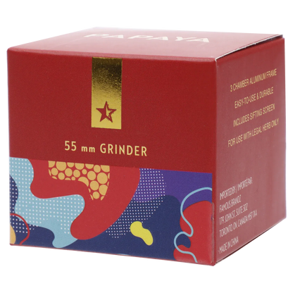 Angled close-up of the red box showing "55 mm GRINDER" and patterned lower panel, featuring the Famous Design Papaya Aluminum 4pc Grinder - Rose Gold name.