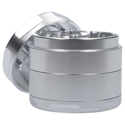 Close-up angled view of the silver Famous Design Space Aluminum 4pc Grinder showing the textured cylindrical body and open top with visible teeth.