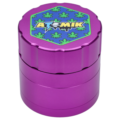 Front view of the Atomik Pixelated 55 mm 3-Stage Grinder, a purple metal grinder with a textured surface.