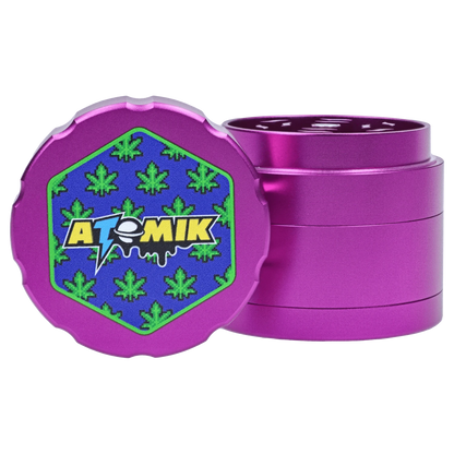 A close-up, angled view of the Atomik Pixelated 55 mm 3-Stage Grinder, showcasing its purple, textured design.