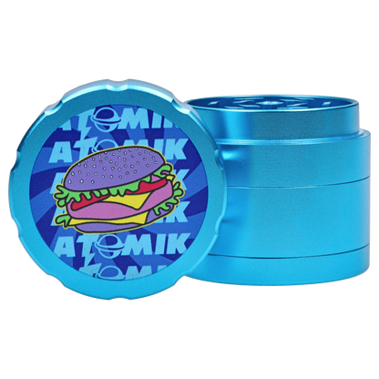 A close-up, angled view of the Atomik Cheesed 55 mm 3-Stage Grinder, showcasing its metallic, tiered construction.