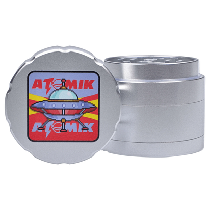 Front view of the Atomik Landed 55 mm 3-Stage Grinder, a metallic, cylindrical grinder with tiered levels, shown against a plain white background.