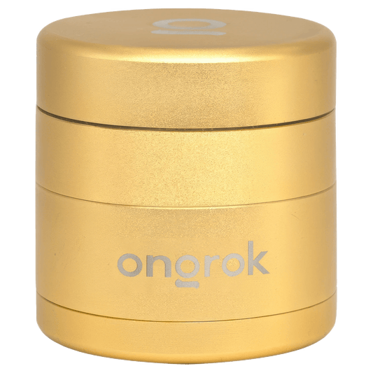 Front view of the Ongrok Mini 4 Piece EZ Grinder in gold, showcasing its compact, multi-tiered design.