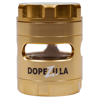 Close-up front view of the gold Dopezilla Space Pod 3-Stage 50 mm Grinder - Air showing its textured cylindrical body, top knurled cap, and rectangular window revealing the mesh screen.