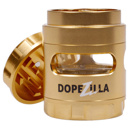 Close-up front view of the gold Dopezilla Space Pod 3-Stage 50 mm Grinder - Air showing its open lid, internal teeth and clear window.