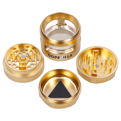 Top-down view of the gold Dopezilla Space Pod 3-Stage 50 mm Grinder - Air disassembled into four circular parts showing tooth patterns, a mesh screen, and branded side.