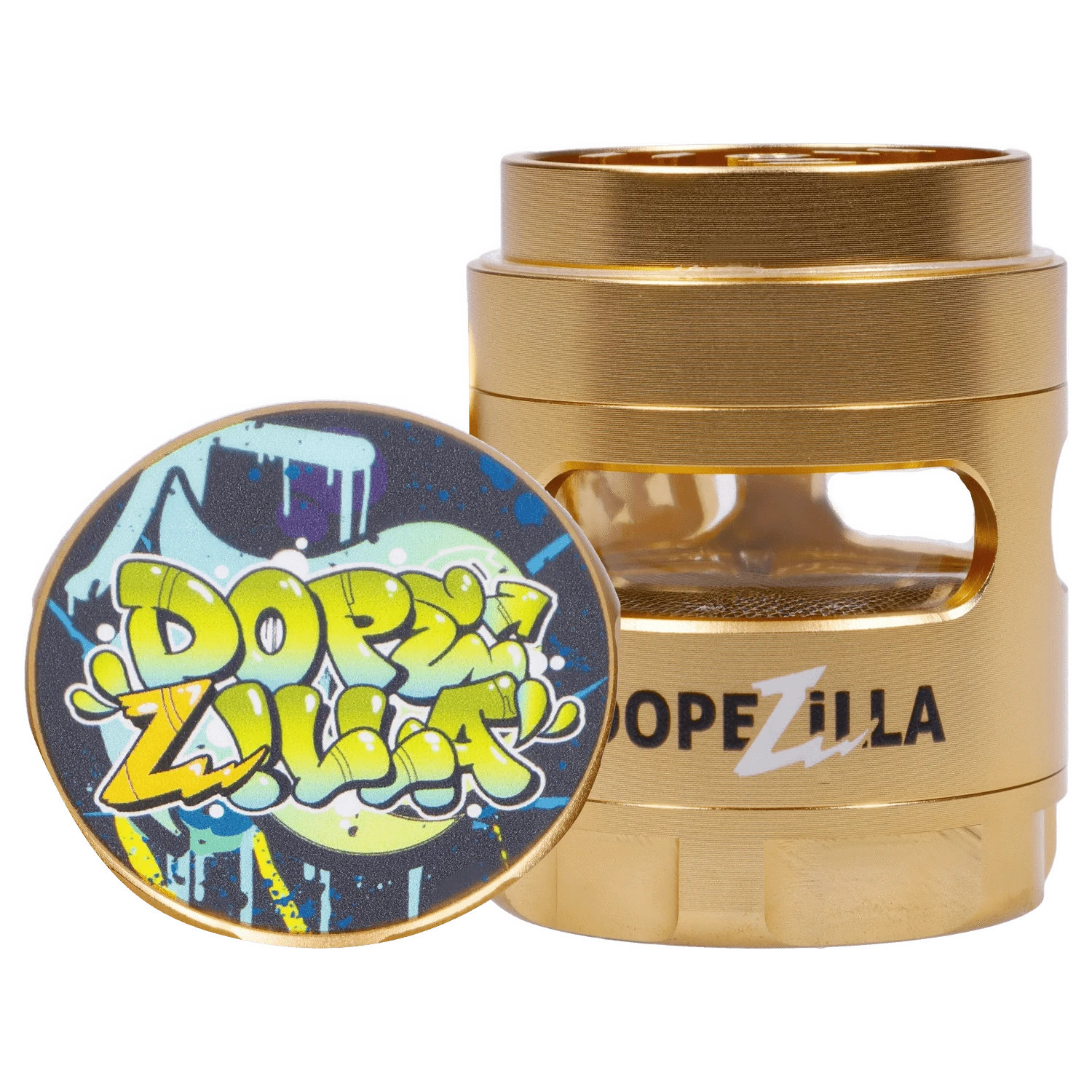 Close-up front angle of the gold Dopezilla Space Pod 3-Stage 50 mm Grinder - Air showing its stacked metal chambers and a colorful graffiti-style lid propped against it.