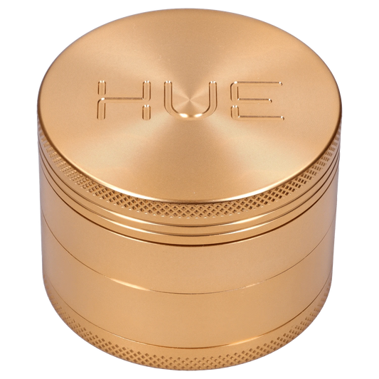 Front view of the Hue 3-Stage Grinder in champagne gold, showcasing its cylindrical, multi-tiered design.