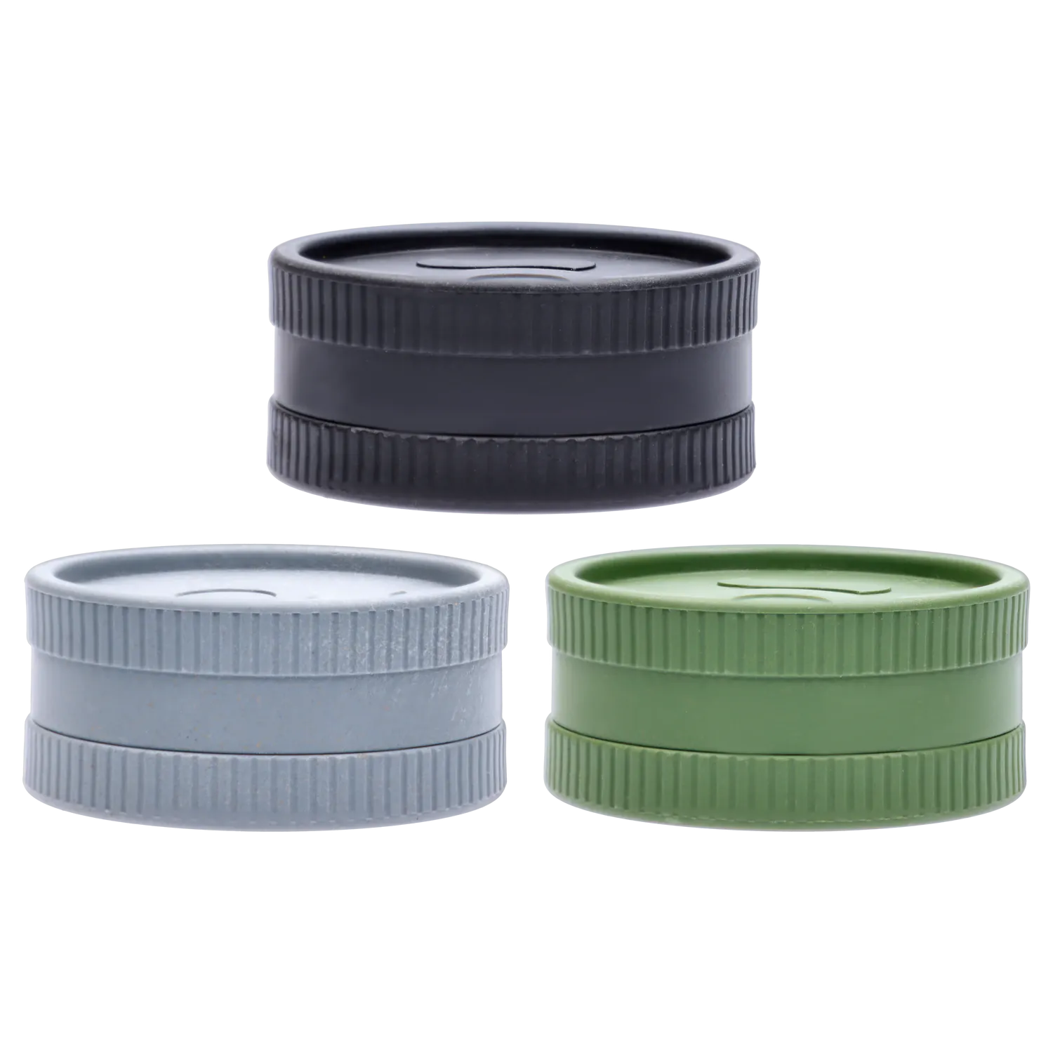 Close-up, straight-on view of three stacked Ongrok - Degradable Grinder - 24/box Assorted Colours pieces in black, gray, and green showing ribbed edges and flat lids.