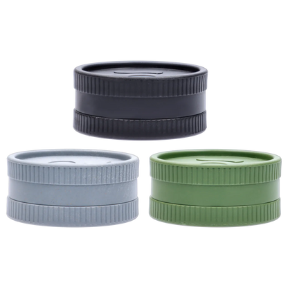 Close-up, straight-on view of three stacked Ongrok - Degradable Grinder - 24/box Assorted Colours pieces in black, gray, and green showing ribbed edges and flat lids.