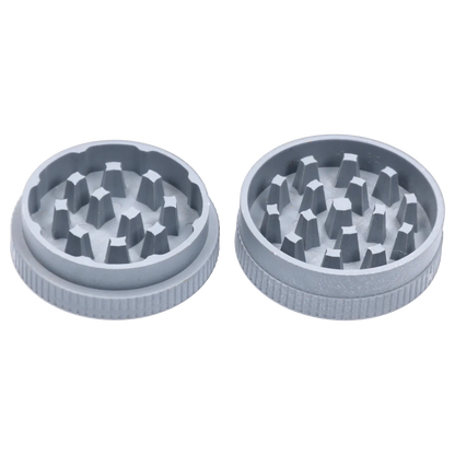 Top-down view of two grey pieces of the Ongrok - Degradable Grinder - 24/box Assorted Colours showing internal teeth and textured outer rims.