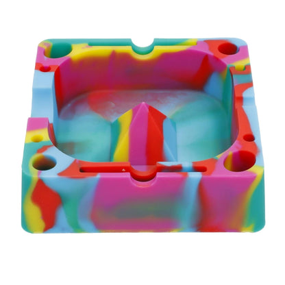 Top-down view of a brightly swirled Valiant Silicone Square Ashtray-Assorted showing its squared cavity, central pyramid ridge, and multiple circular rests.