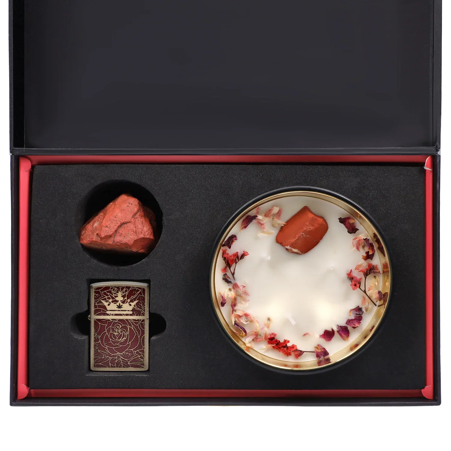 Top-down view of the Queen of Bud: Passion Ritual Box – Candle, Zippo, and Crystal showing a round flower-topped candle, a red raw crystal, and a ornate red Zippo set in black foam.