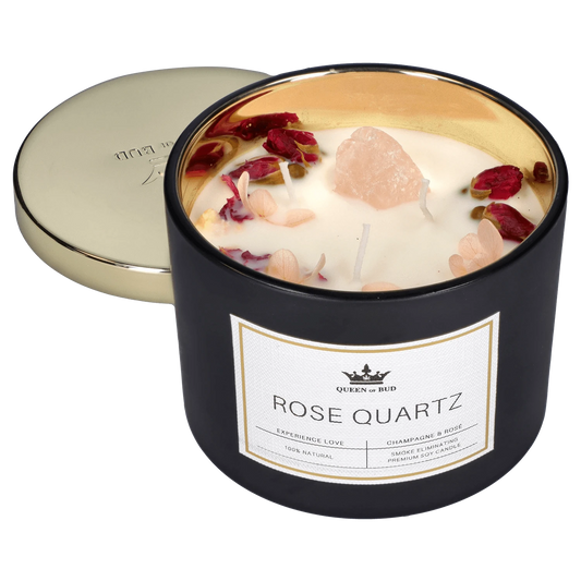 Front view of the Queen of Bud Candle - Rose Quartz, lit with a pink hue against a neutral background.