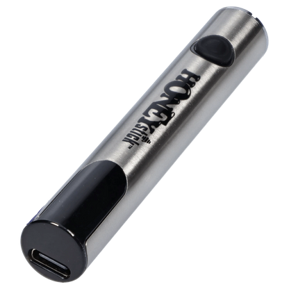 Angled close-up of the silver HoneyStick Digital Battery - Silver Carton showing its brushed metal tube, black button and USB-C charging end.