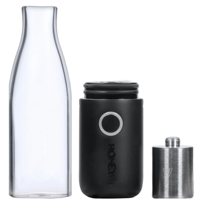 Close-up front view of the disassembled HNY HoneyStick Lil Ripper showing its clear glass mouthpiece, black battery body with circular button, and stainless steel chamber.
