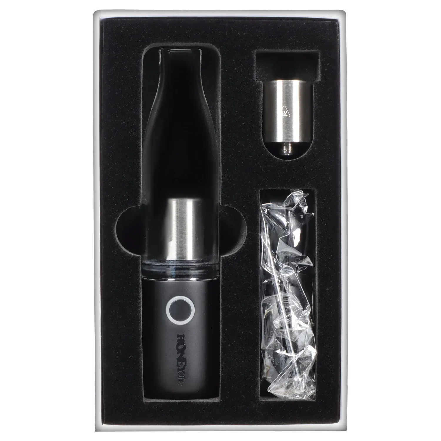 Top-down view of the HNY HoneyStick Lil Ripper in black nestled in foam packaging alongside a metal cartridge and wrapped accessories.